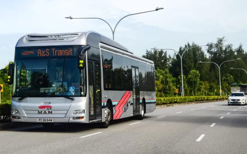 A&S Transit modern single-deck corporate charter bus driving along a Singapore road.